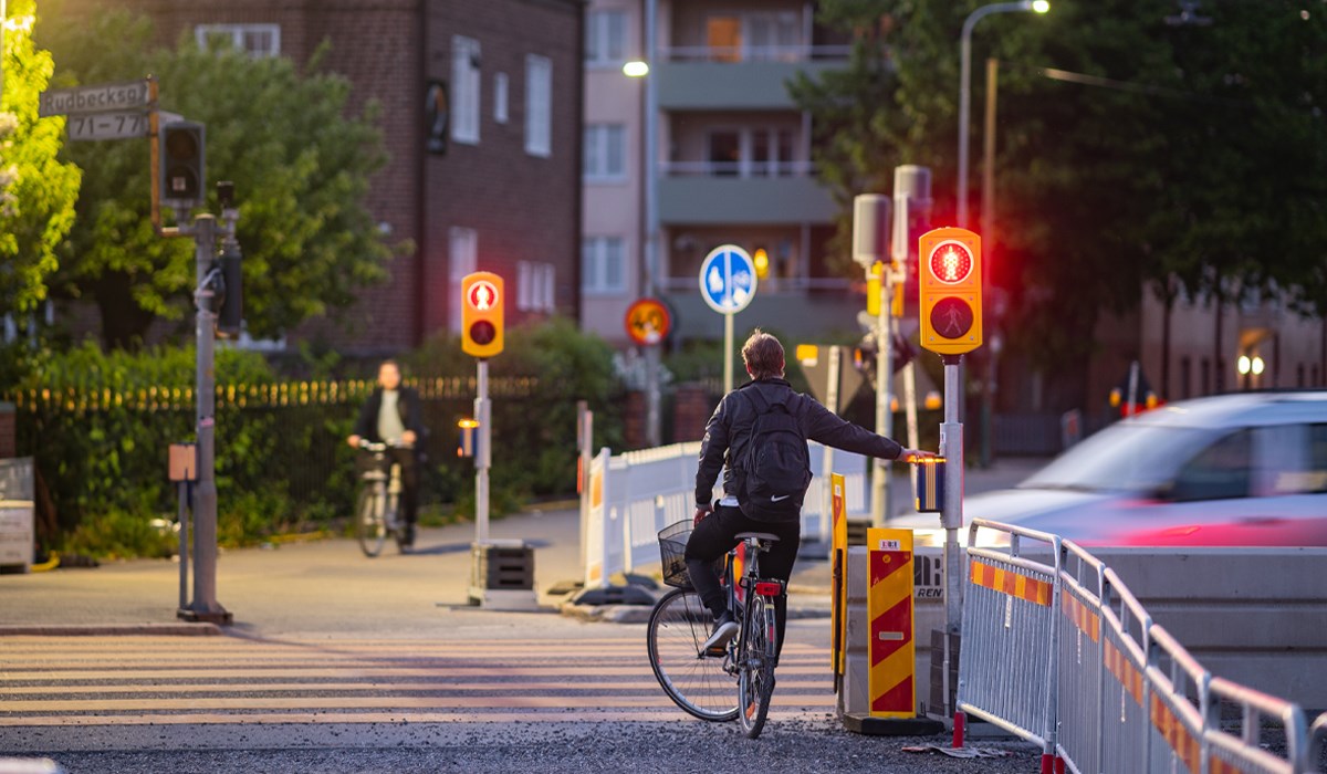 Cyklist väntar vid tillfälliga övergångssignaler